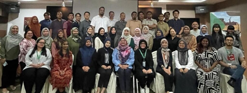 A large group of people sit smiling and posing for a photo. 